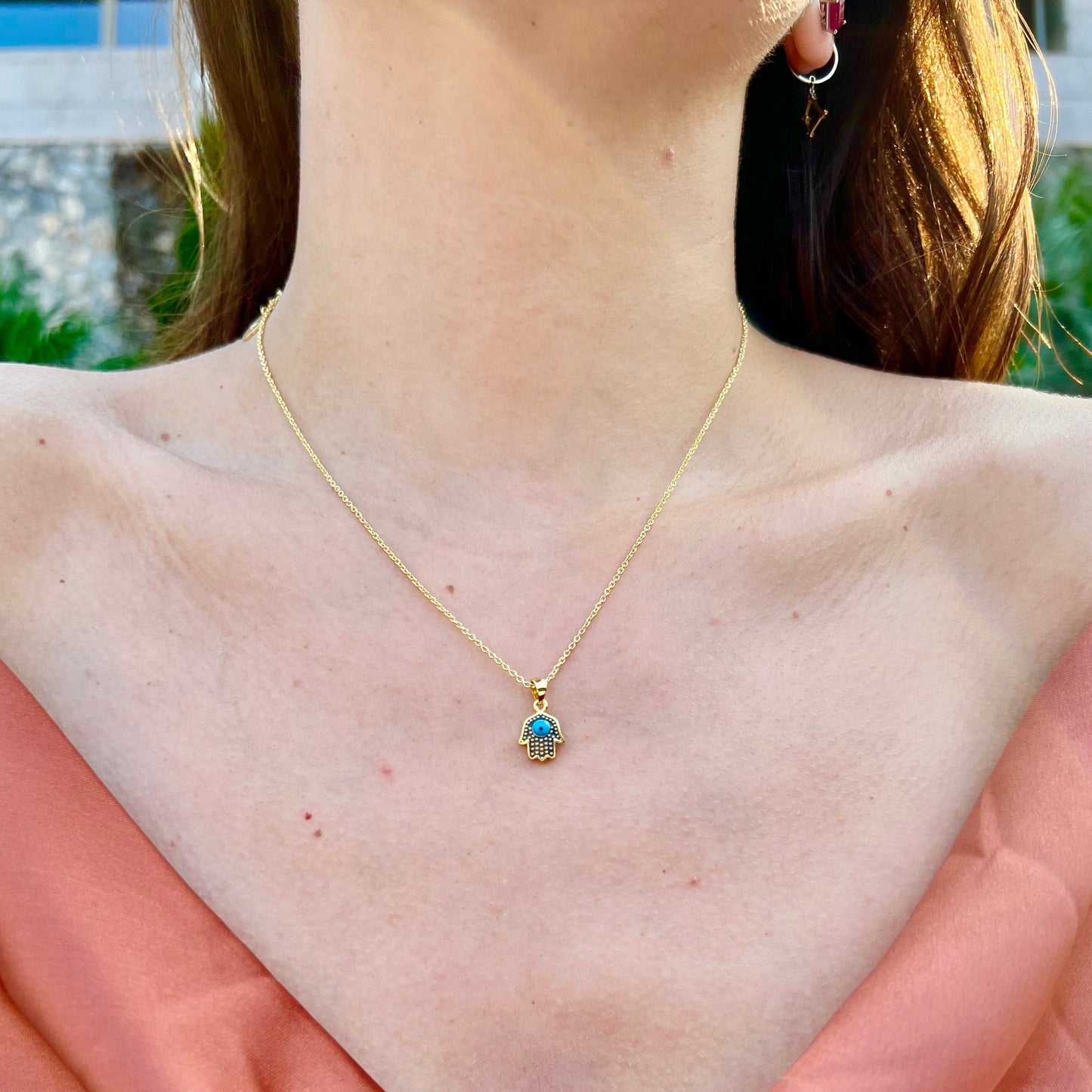 Gold Hamsa necklace with blue gem