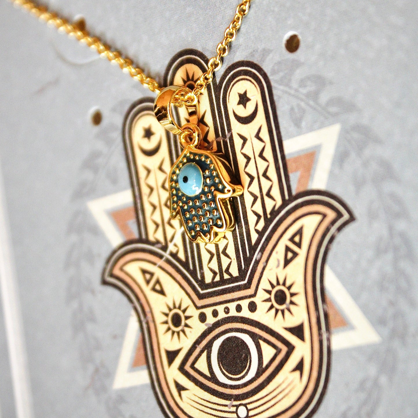 Gold Hamsa necklace with blue gem